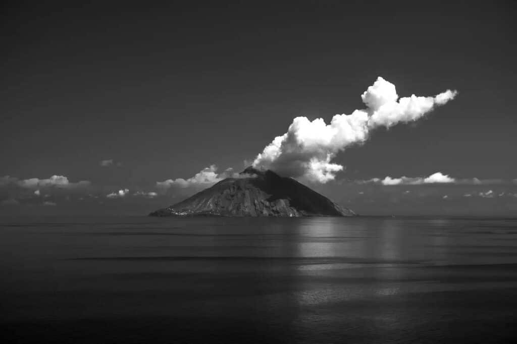 volcan stromboli, noir et blanc, depuis la mer, nuage ou fumée